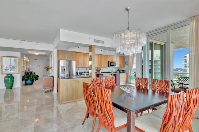 dining space featuring track lighting and an inviting chandelier