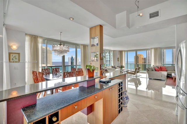 kitchen featuring a healthy amount of sunlight, a water view, and pendant lighting