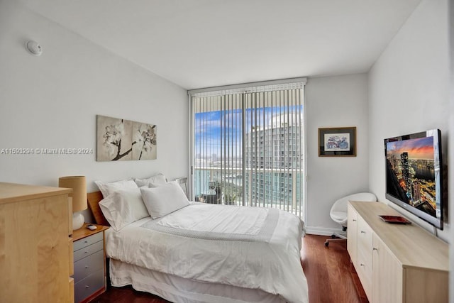 bedroom with dark hardwood / wood-style floors and access to outside