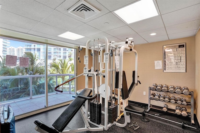 workout area with a paneled ceiling and plenty of natural light