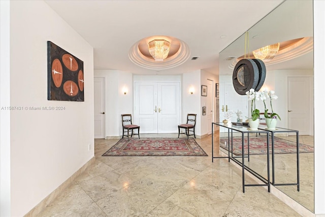 hallway featuring a tray ceiling and tile flooring