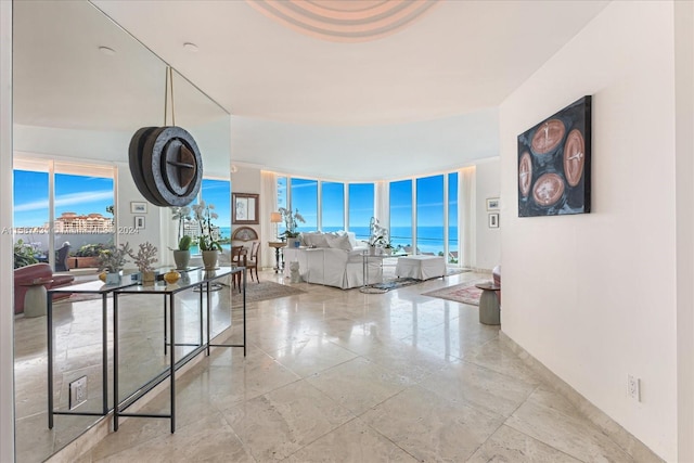 hall featuring a water view, expansive windows, and light tile floors