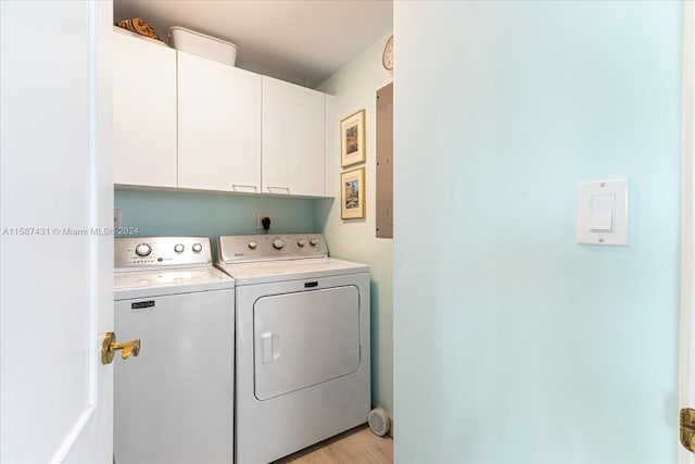 laundry room featuring light hardwood / wood-style floors, washing machine and clothes dryer, hookup for an electric dryer, and cabinets