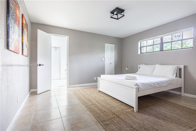 tiled bedroom with a closet