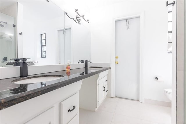 bathroom with tile floors, toilet, and vanity