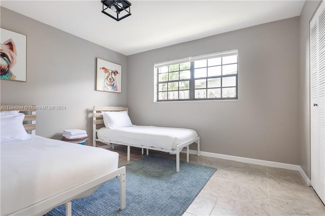 bedroom with a closet and light tile floors