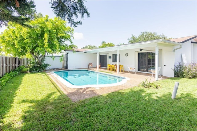 view of swimming pool with a yard, ceiling fan, and a patio area