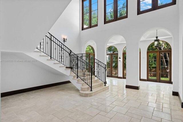 tiled entrance foyer featuring a high ceiling and french doors