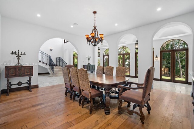 dining area featuring a notable chandelier, light hardwood / wood-style flooring, and french doors