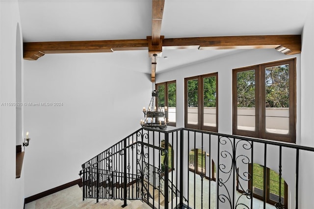 stairs with beamed ceiling and a notable chandelier