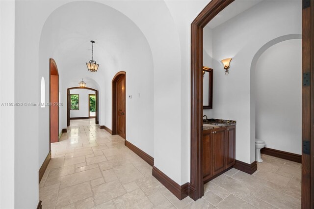 hall with a high ceiling and light tile floors