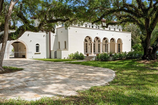 mediterranean / spanish-style home with a front lawn