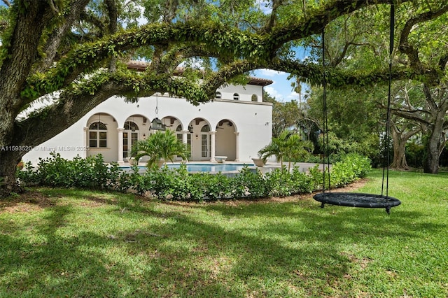 rear view of property featuring a lawn