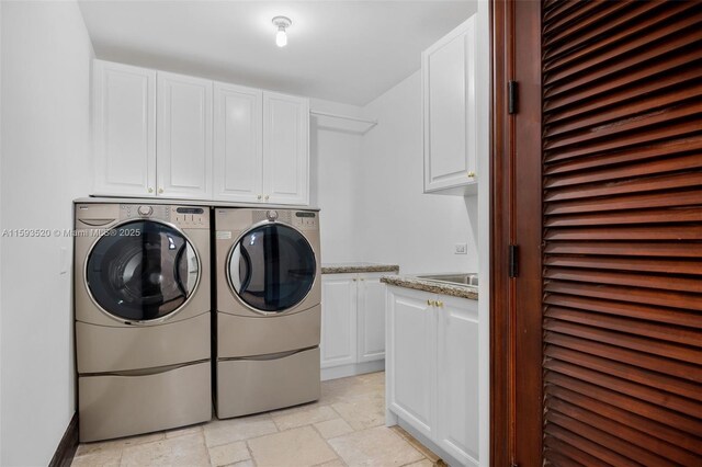 laundry area with washer and clothes dryer, cabinets, and light tile floors