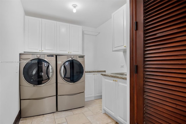 washroom featuring cabinets and washer and clothes dryer