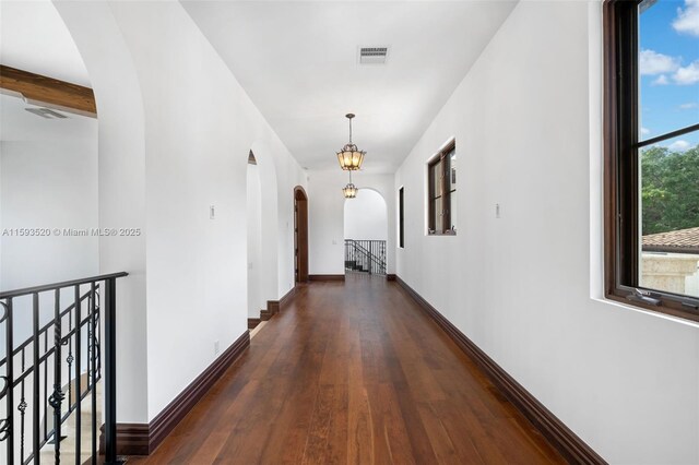 hall with dark hardwood / wood-style flooring and beam ceiling