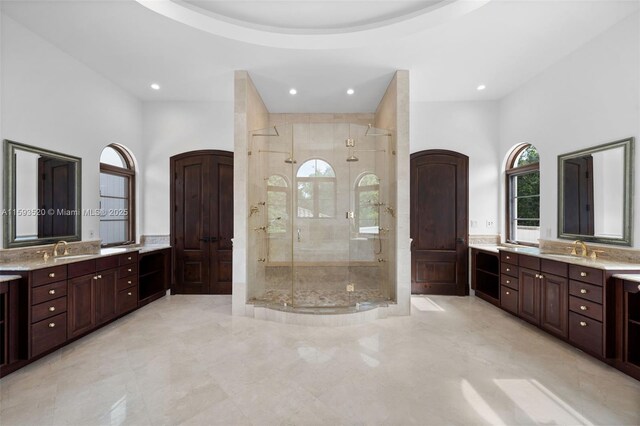 bathroom with a shower with door, tile flooring, and vanity