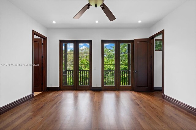 spare room with dark hardwood / wood-style flooring, ceiling fan, and french doors