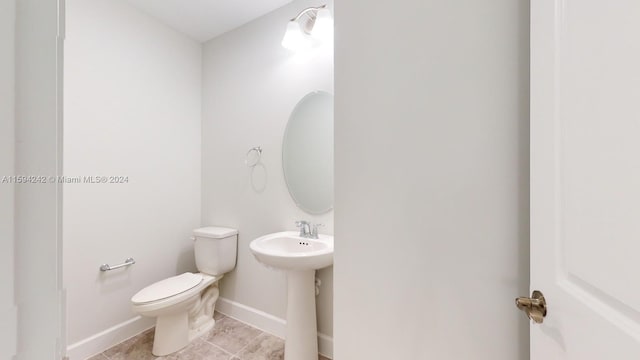 bathroom featuring tile flooring and toilet