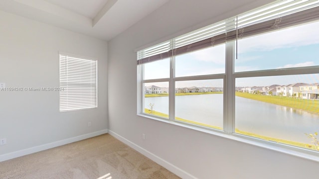 empty room with carpet flooring and a water view