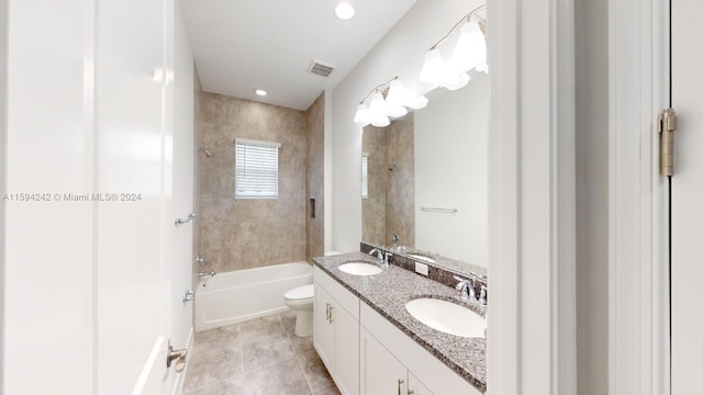 full bathroom featuring tile floors, dual vanity, toilet, and tiled shower / bath combo