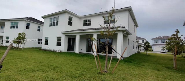 back of property featuring a garage and a yard