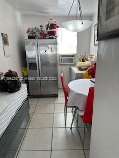 kitchen featuring pendant lighting, tile counters, stainless steel fridge, and light tile patterned floors