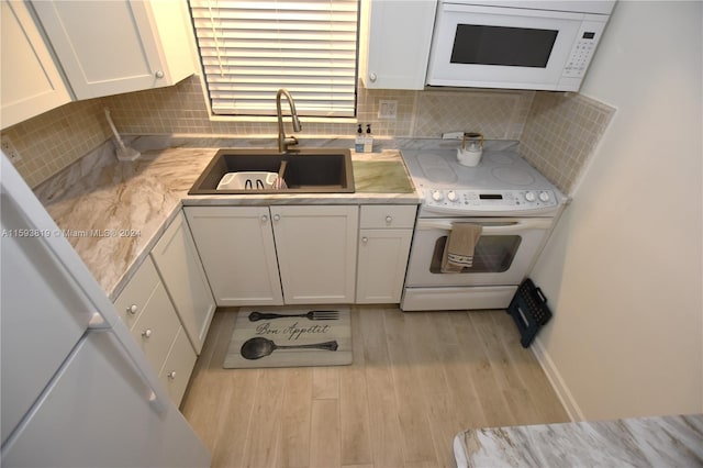 kitchen with tasteful backsplash, white appliances, sink, and white cabinetry