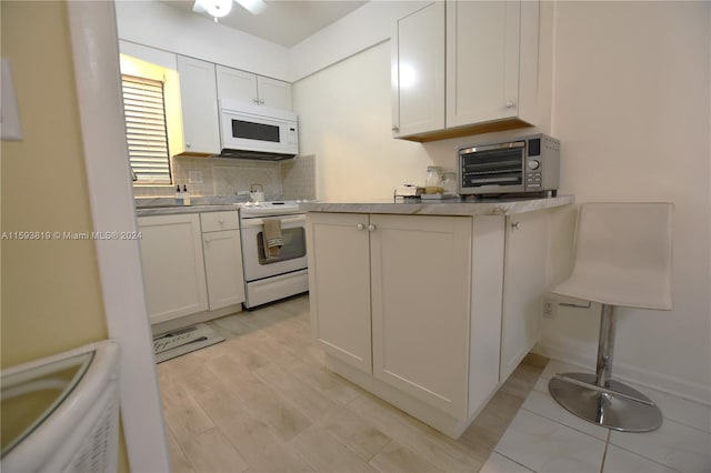 kitchen featuring white cabinetry, kitchen peninsula, white appliances, light wood-type flooring, and tasteful backsplash