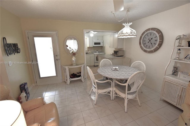 tiled dining space with ceiling fan