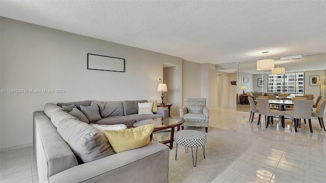 living room with a textured ceiling and light tile flooring