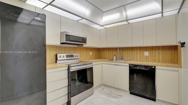 kitchen featuring sink, gray cabinets, light tile floors, and stainless steel appliances