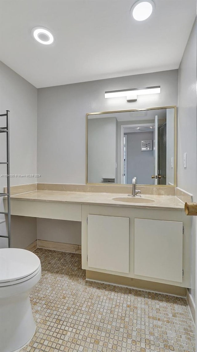 bathroom with tile flooring, vanity, and toilet