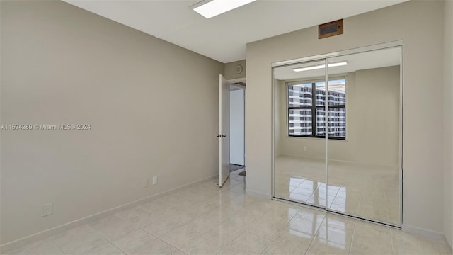 unfurnished bedroom featuring a closet and light tile flooring