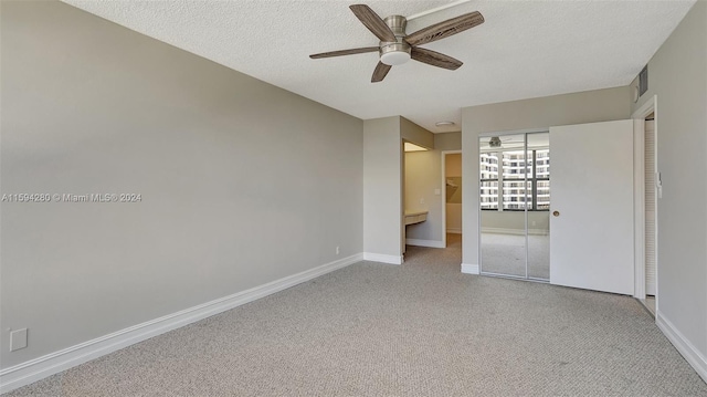 unfurnished bedroom with carpet, ceiling fan, a closet, and a textured ceiling