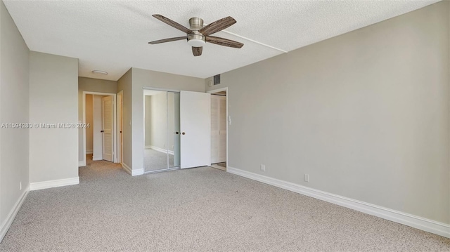 unfurnished bedroom featuring a textured ceiling, carpet flooring, and ceiling fan