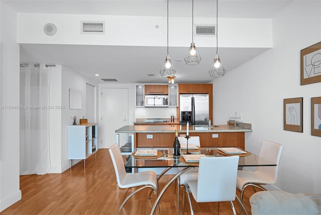 dining space featuring sink and light wood-type flooring