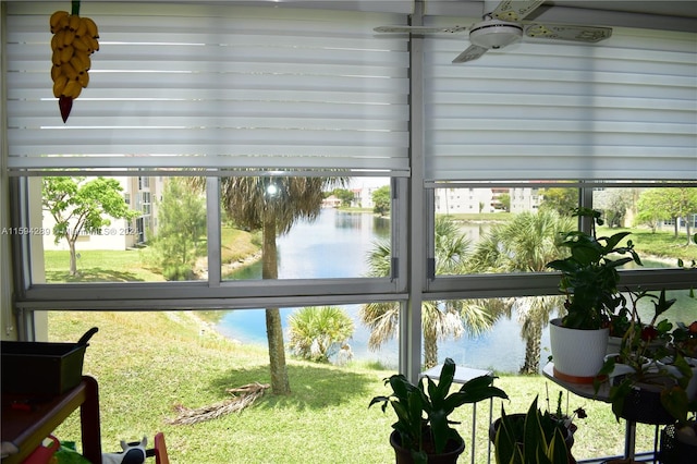 interior space with ceiling fan and a water view