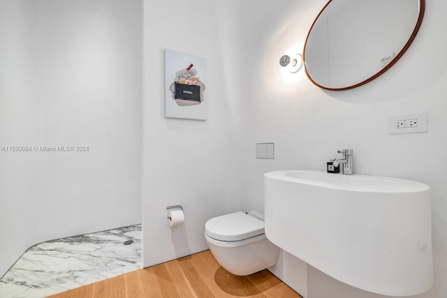 bathroom featuring wood-type flooring and toilet