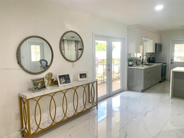 interior space with a healthy amount of sunlight, french doors, and electric range oven