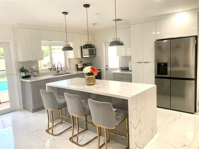 kitchen with appliances with stainless steel finishes, sink, a center island, and tasteful backsplash