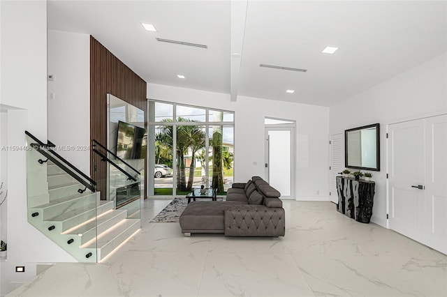 living room featuring lofted ceiling with beams and light tile floors