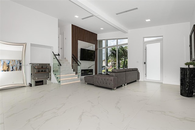 living room featuring beam ceiling and light tile flooring