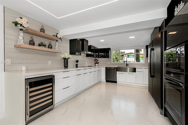 kitchen featuring wine cooler, black appliances, wall chimney exhaust hood, sink, and white cabinets