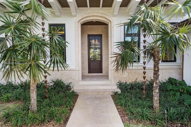 doorway to property featuring stucco siding