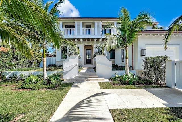 view of front of home featuring a balcony and a front yard