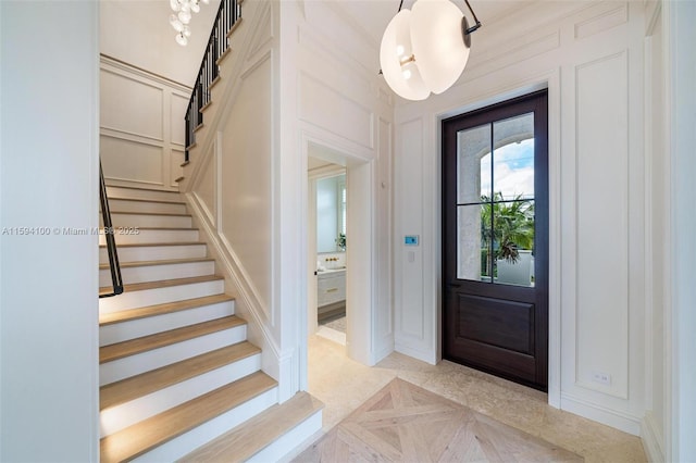 foyer entrance featuring stairway and a decorative wall