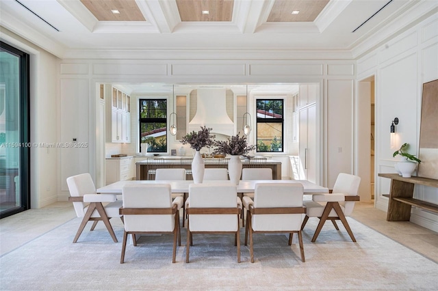 dining area with crown molding, a healthy amount of sunlight, coffered ceiling, and a decorative wall