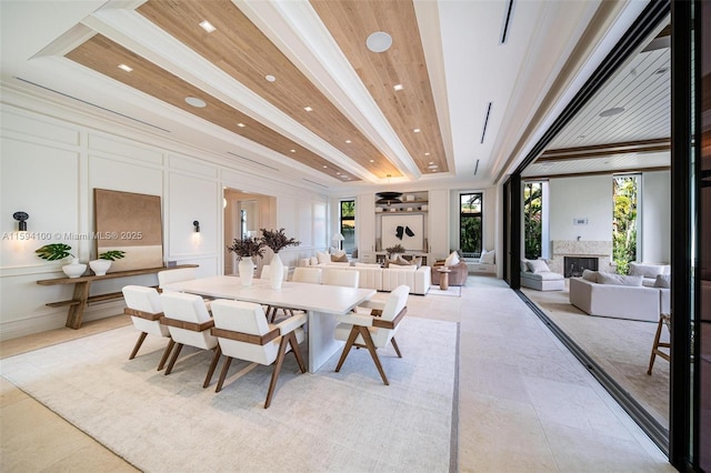 dining space with recessed lighting, wooden ceiling, a fireplace, and a decorative wall