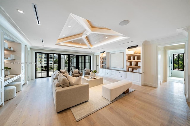 living area with light wood-style flooring, built in shelves, ornamental molding, and a raised ceiling